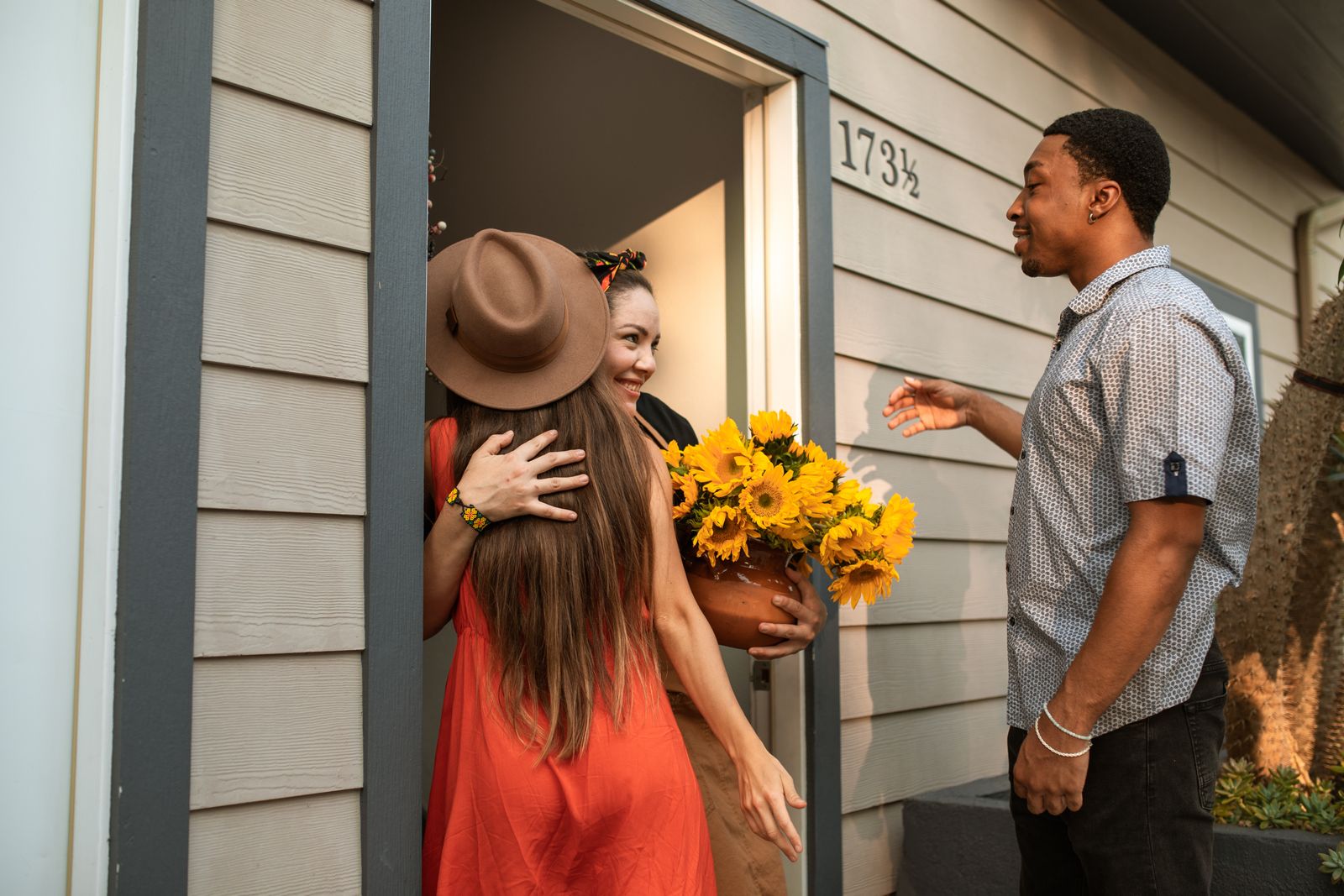 A parishioner welcoming a visitor at the open red doors of the church
